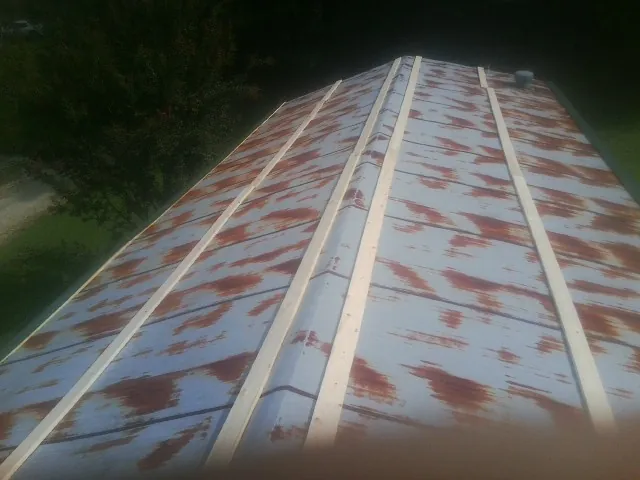 Rusted metal roof panels with new wood purlins before replacement — Storm Damage Roof Repair in Sunbury by Roofing Brothers